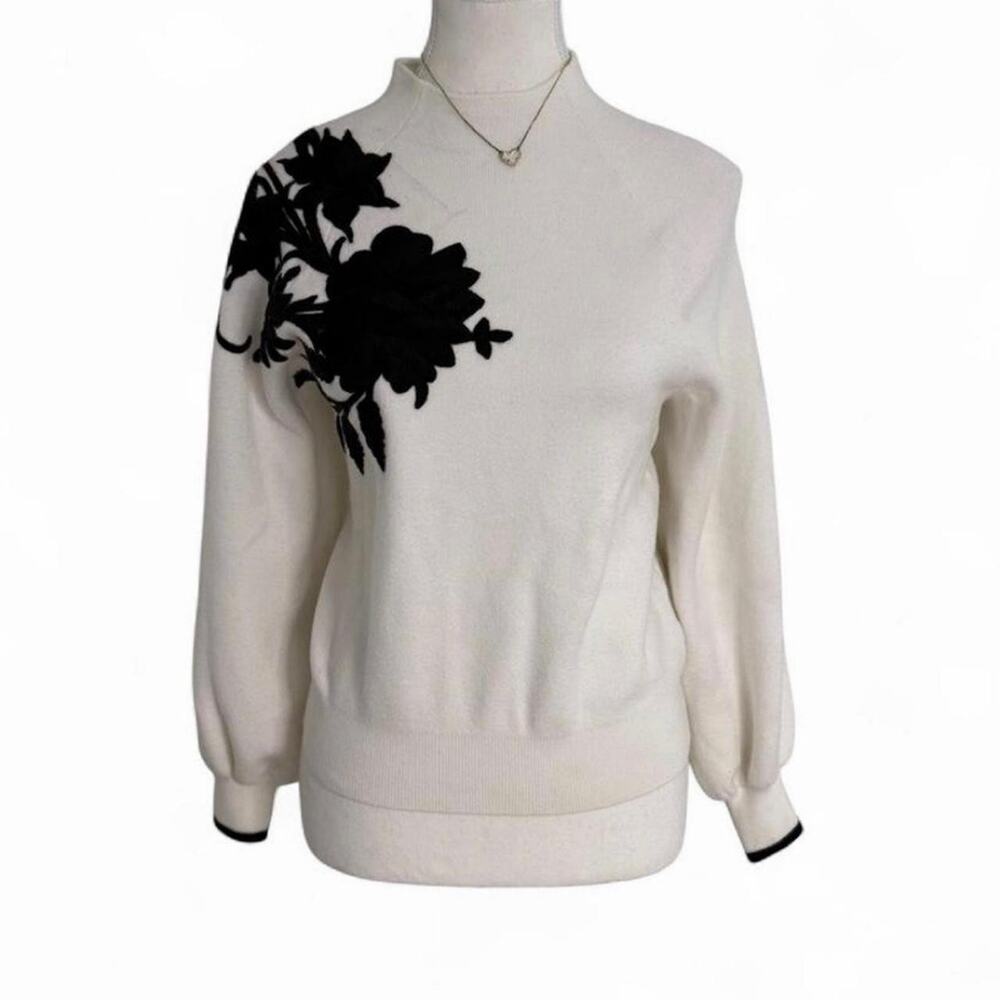 Anthropologie cream sweater with black floral design on the shoulder, size XS